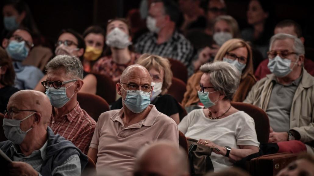 Des personnes portent un masque en attendant le début d'une pièce de théâtre à Paris, le 22 juin 2020. - Stéphane de Sakutin - AFP