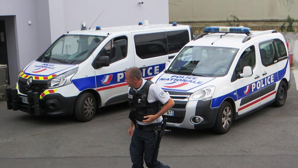 Un policier devant deux véhicules de la police Wikimedia