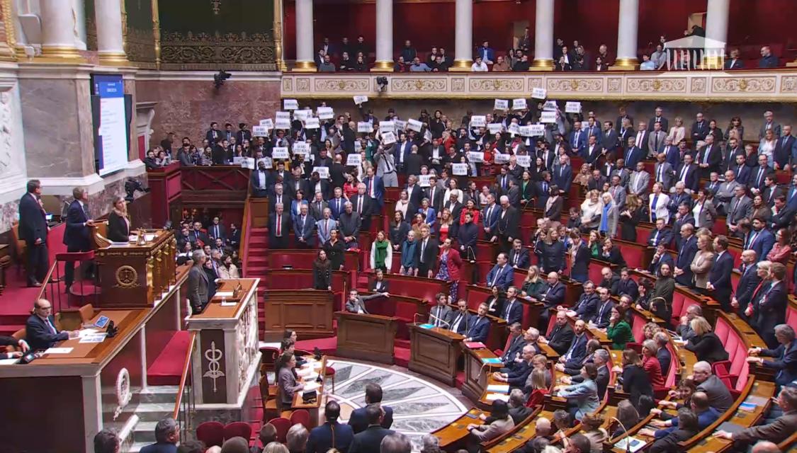 Elisabeth Borne à la tribune de l'Assemblée nationale alors que l'opposition de gauche chante la Marseillaise pour protester contre l'utilisation du 49.3.