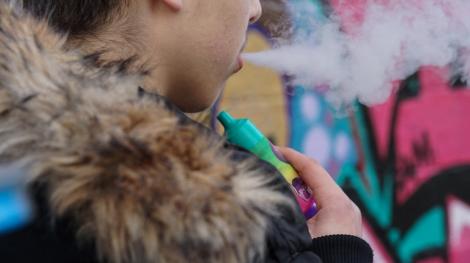 Un jeune homme fume une "puff".