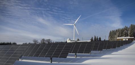 Photo de panneaux solaires et d'une éolienne. DR